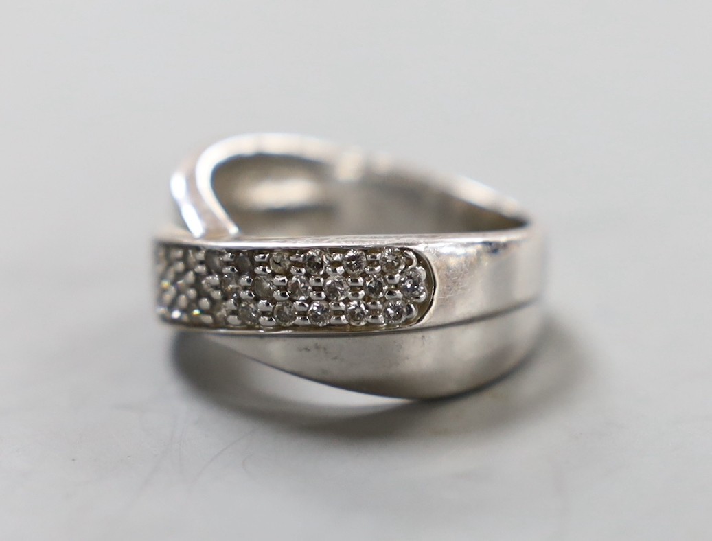 A modern 14k white metal and three row diamond chip set crossover ring, size N, gross weight 5.8 grams.